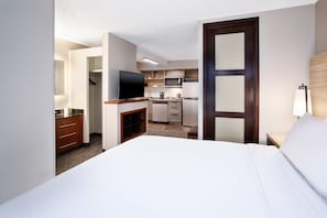 A hotel room with a bed, a TV, a kitchenette, and a walk-in closet. - Candlewood Suites Cincinnati Northeast - Mason (Mason)