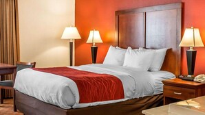 Habitación de hotel con cama, dos lámparas de noche, un escritorio y una silla.