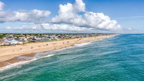 A coastal beach with houses along the shore, a clear sky, and waves approaching the beach. - Holiday Inn Express Kitty Hawk Outer Banks (Kitty Hawk)