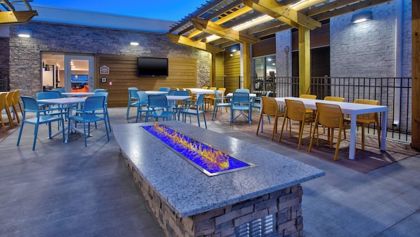 An outdoor patio with seating, a fire feature, and a TV mounted on the wall. - Holiday Inn Express Kitty Hawk Outer Banks (Kitty Hawk)