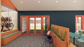 A modern indoor space with a seating area, a glass wall with bicycles, and a view of a green landscape through large glass doors. - Loge St. George (St. George)