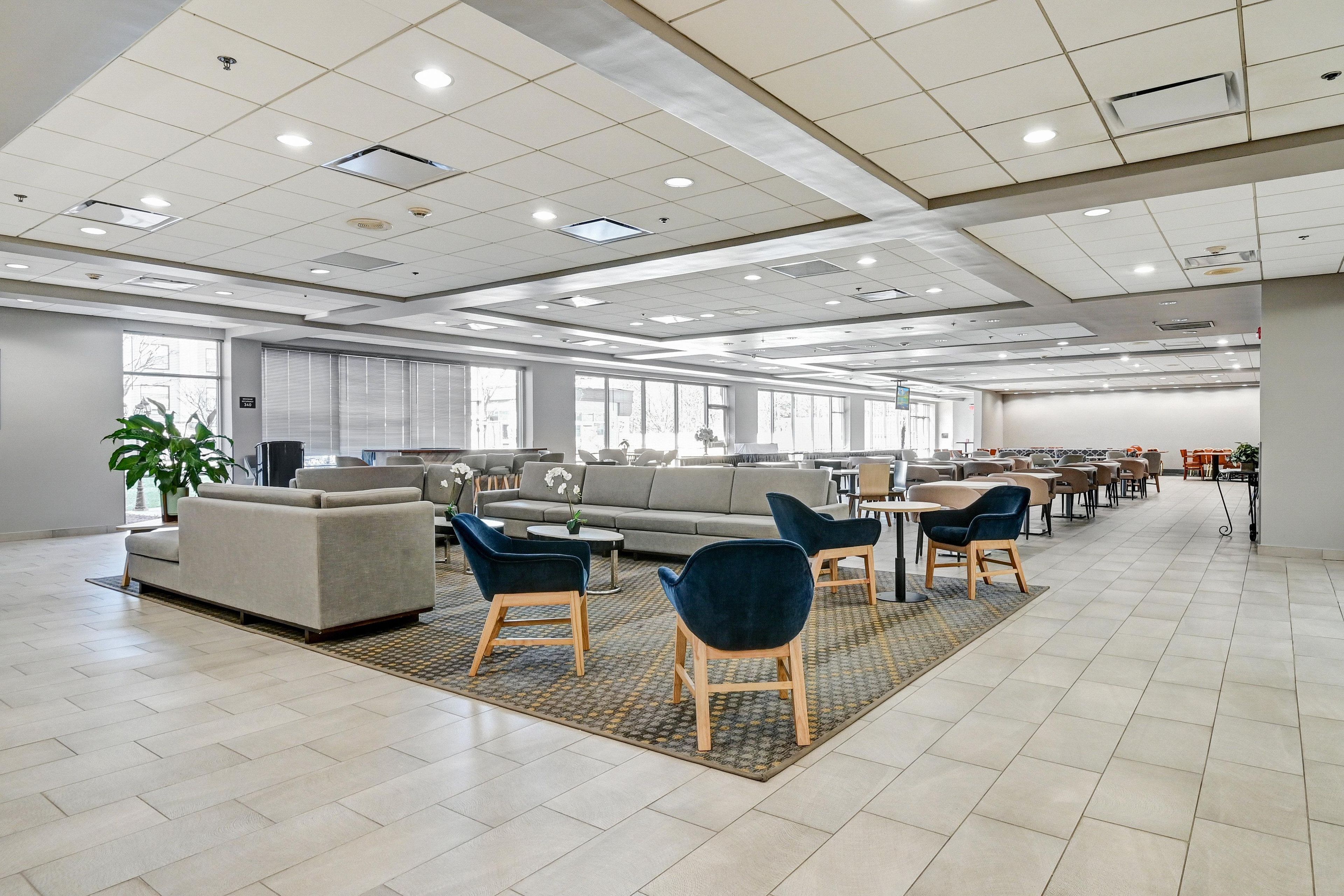 A spacious indoor area with a large sofa, chairs, and a dining area.