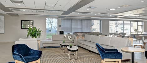Ein großzügiger Loungebereich mit Sofas, Sesseln und einem gemusterten Teppich.