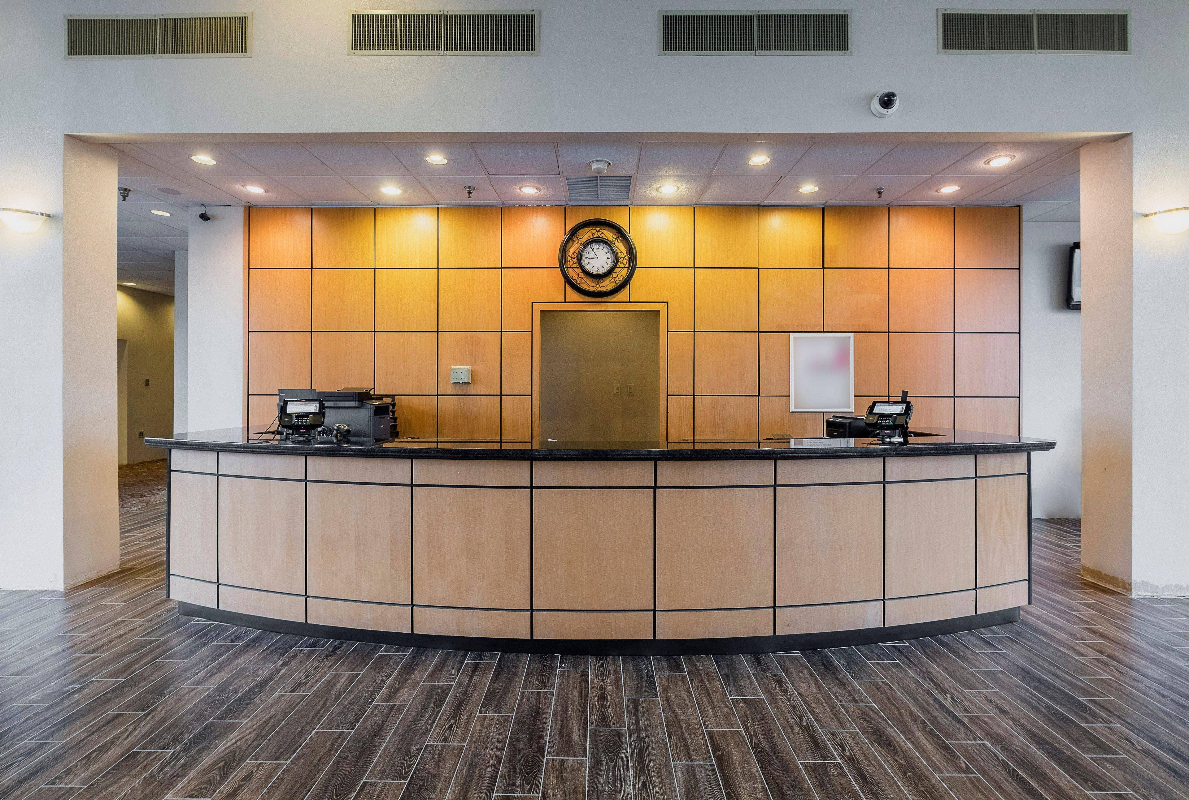 A reception desk with a clock, a cash register, and a telephone.