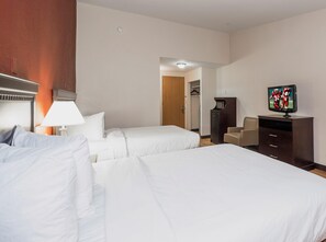 Une chambre d’hôtel avec deux lits, une télévision, un bureau et une armoire.