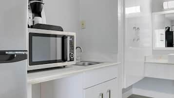 A modern kitchen with a microwave, coffee maker, and a sink.