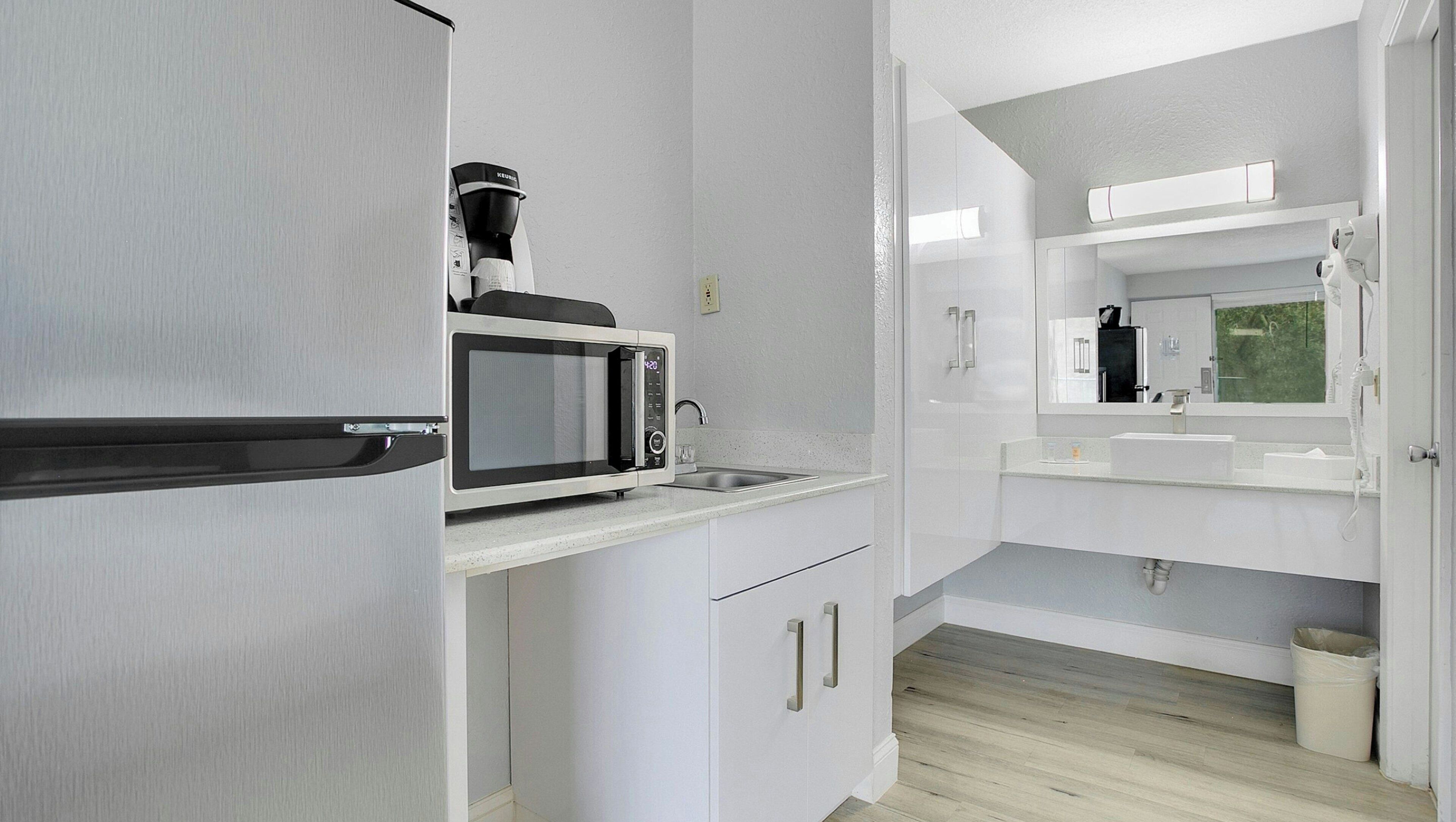 A modern kitchen with a built-in microwave, a coffee maker, and a sink.