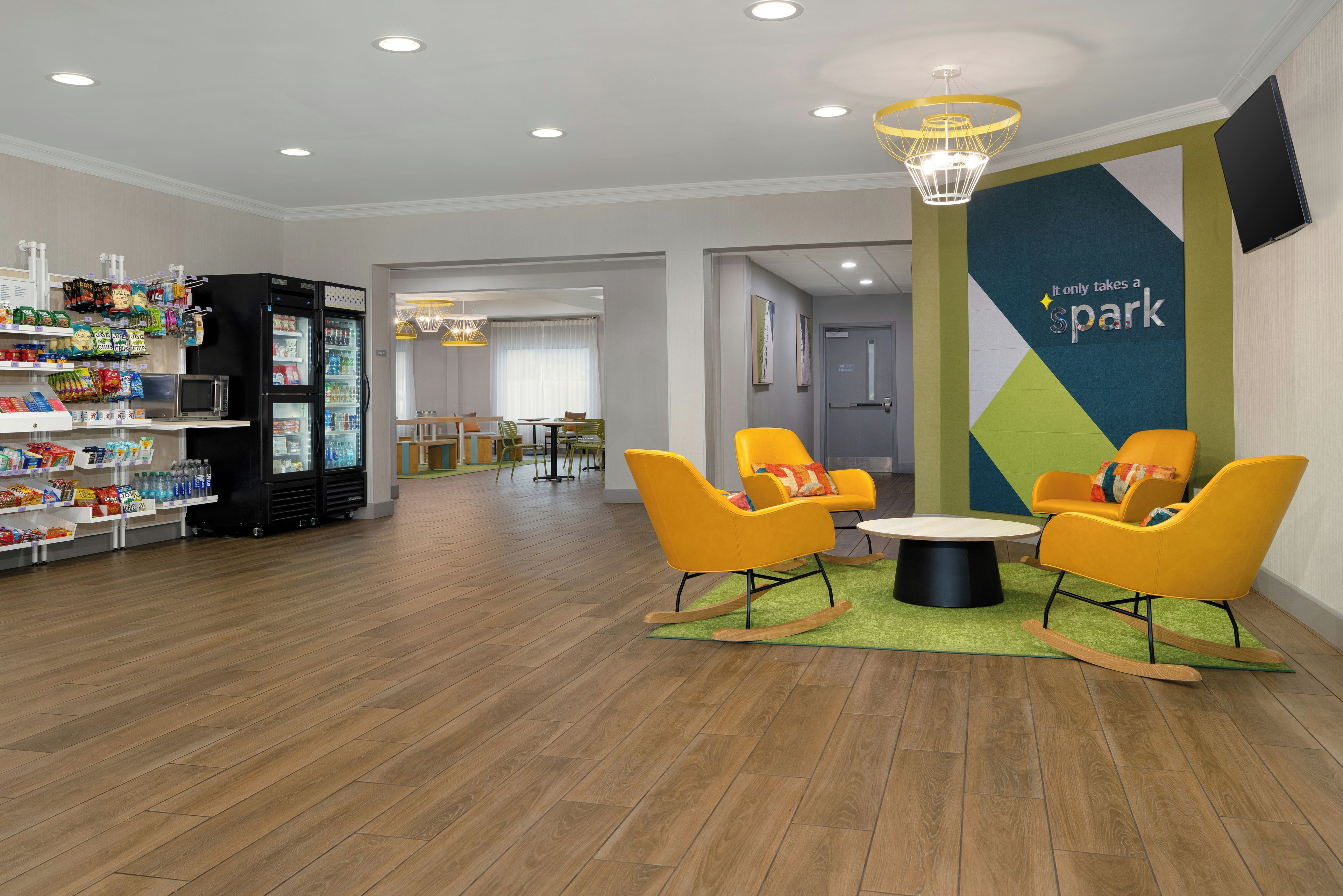 A modern lobby with a vending machine, seating area, and a wall with motivational text.