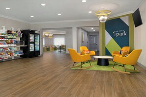 A modern lobby with a vending machine, seating area, and a wall with motivational text. - Spark by Hilton Rahway (Rahway)