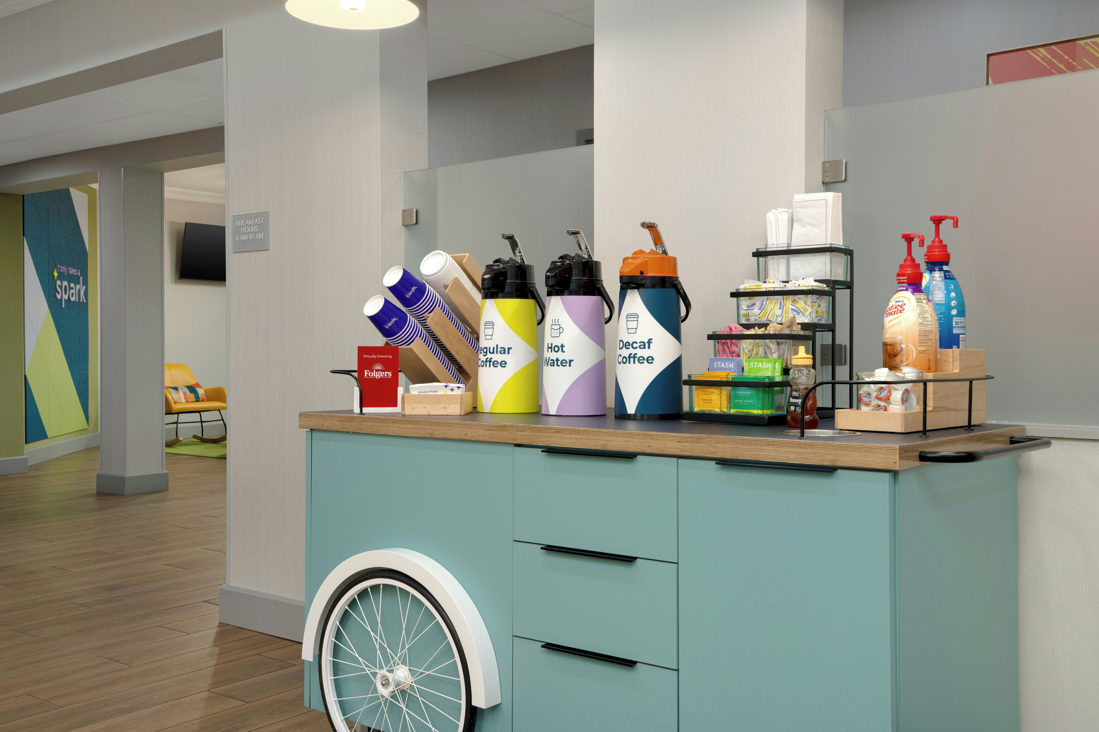 Eine Selbstbedienungsstation für Getränke mit Kaffee- und Wasserspendern, einer Kaffeemaschine und einer Flasche Handseife.