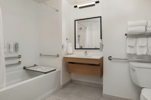 Um banheiro moderno com banheira, chuveiro, pia e vaso sanitário.