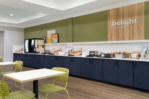 A modern kitchen area with a counter, seating, and a wall sign that reads 'Delight in the day.' - Spark by Hilton Rahway (Rahway)