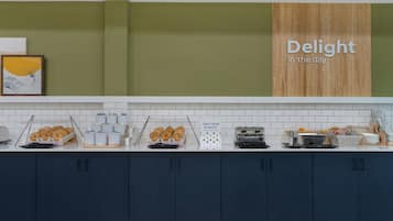 A breakfast buffet with various food items and a sign that reads 'Delight in the day'.