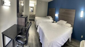 A hotel room with two beds, a desk, and a chair. - Griffin Inn & Suites (Griffin)