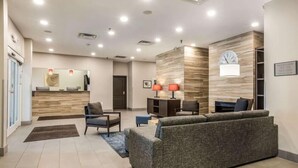 A modern reception area with a sofa, chairs, a desk, and a clock on the wall. - Comfort Inn & Suites Fairburn - Atlanta Southwest (Fairburn)