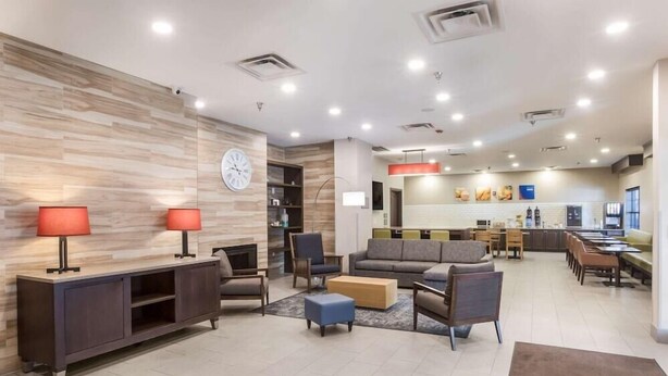 A modern hotel lobby with a seating area, a kitchen, and a dining area. - Comfort Inn & Suites Fairburn - Atlanta Southwest (Fairburn)