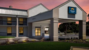 A modern hotel with a covered entrance, a sign for Suburban Studios, and a clear sky. - Suburban Studios Hinesville - Fort Stewart Area (Hinesville)