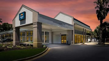 A hotel with a clear entrance, a sign for 'Suburban Studios,' and a 'Clearance' sign.