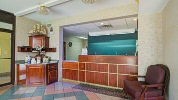 A reception area with a wooden desk, a ship model, a clock, and a reception counter.