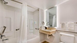 Une salle de bain équipée d’une baignoire, de toilettes, d’un lavabo et d’un miroir.