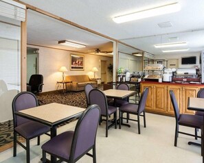 A hotel room with a dining area, a sofa, and a kitchenette. - Quality Inn University Area Farmville, VA (Farmville)