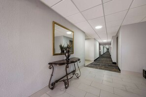 A hallway with a console table and a mirror on the wall.