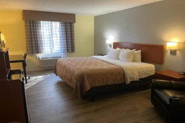 Una camera d'albergo con un letto, comodini, una scrivania e una sedia.