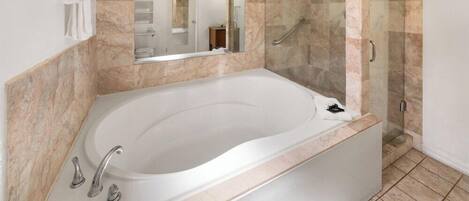 A modern bathroom with a freestanding bathtub, a glass-enclosed shower, and a large mirror.