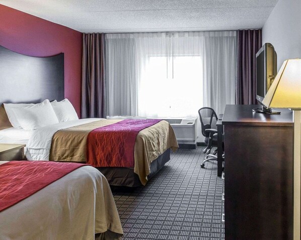 A hotel room with two beds, a desk, a chair, and a lamp. - Clarion Hotel & Suites BWI Airport North (Baltimore)