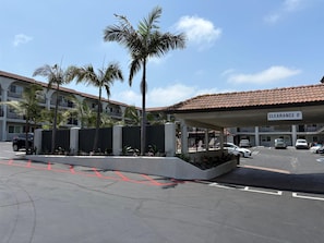 A hotel entrance with a covered parking area, palm trees, and a sign indicating a clearance height of 8 feet. - Best Western San Diego Pacific Beach/mission Bay (San Diego)