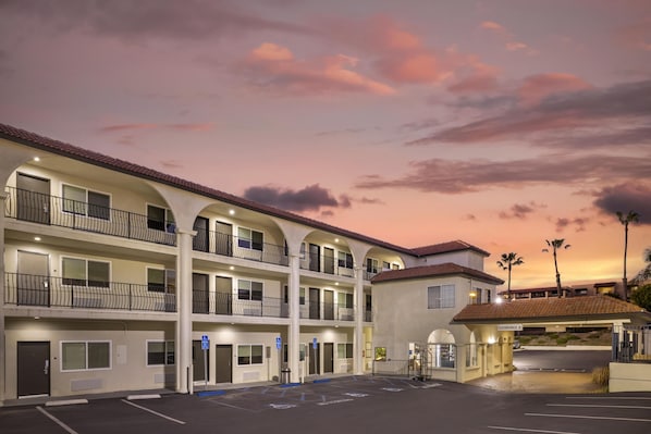 A multi-story hotel with balconies, a parking lot, and a clear sky. - Best Western San Diego Pacific Beach/mission Bay (San Diego)