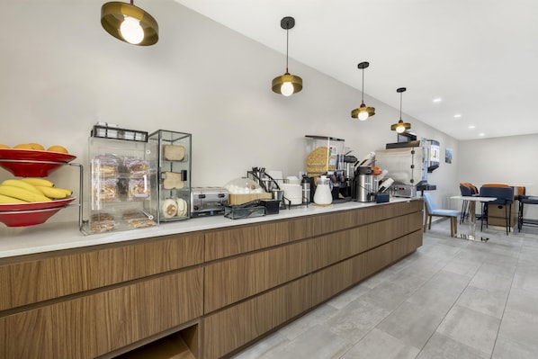 Una cocina moderna con encimera de madera, diversos alimentos y electrodomésticos.