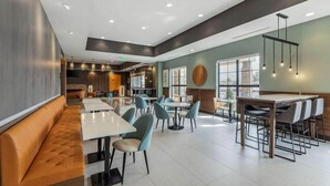 A modern restaurant with high ceilings, recessed lighting, and a mix of seating options including booths and tables. - Comfort Suites Cheyenne, WY (Cheyenne)