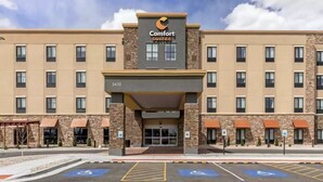 A Comfort Suites hotel with a modern facade, multiple floors, and a parking lot with handicapped spaces. - Comfort Suites Cheyenne, WY (Cheyenne)