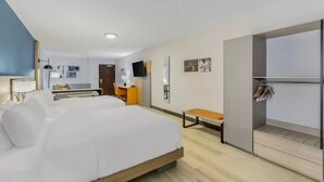 A hotel room with a large bed, a desk, a chair, and a bench. - Comfort Suites Cheyenne, WY (Cheyenne)