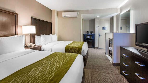 A hotel room with two beds, a TV, a dresser, and a bathroom visible through an open door. - Best Western Inn & Suites San Diego - Zoo/seaworld Area (San Diego)