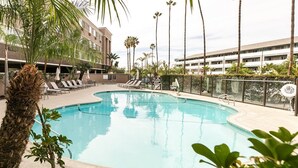 A swimming pool with lounge chairs, palm trees, and a building in the background. - Best Western Inn & Suites San Diego - Zoo/seaworld Area (San Diego)