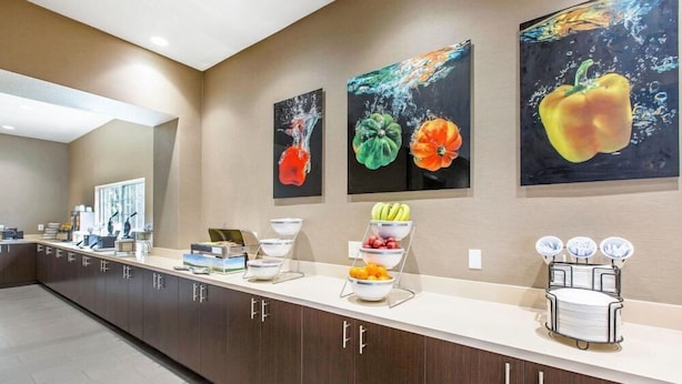 A modern kitchen with a long counter, fruit bowls, and a coffee machine. - Best Western Inn & Suites San Diego - Zoo/seaworld Area (San Diego)