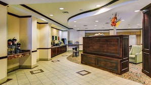 A hotel lobby with a reception desk, seating area, and a decorative vase. - Motel6 Fort Worth, TX I-35 & I-20 (Fort Worth)