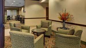 A hotel lobby with patterned armchairs, a round table, and a vase with flowers. - Motel6 Fort Worth, TX I-35 & I-20 (Fort Worth)