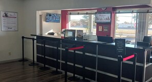 A pet grooming station with a counter, a clock, and informational posters. - Red Roof Inn Fort Worth West (Fort Worth)