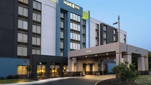 Un edificio moderno de hotel con un letrero que dice "HOME SUITES BY HILTON".