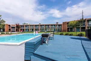 Una piscina con cubierta azul, rodeada por un edificio de ladrillo con varios balcones.