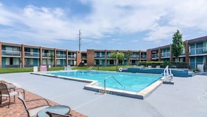 A swimming pool with a 3 ft depth marker, surrounded by a brick patio with outdoor seating. - Rest and Relax Inn (Pensacola)