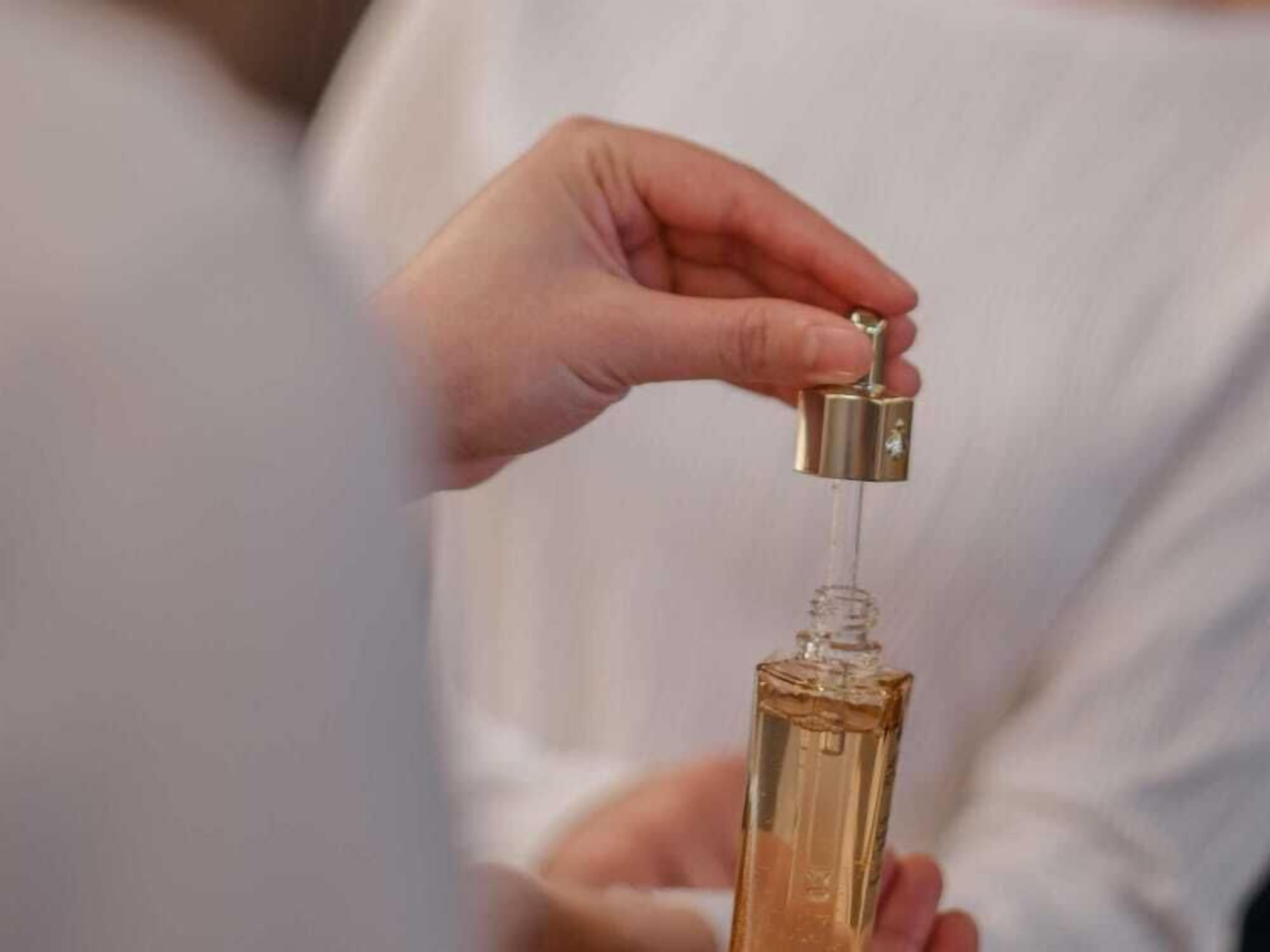 Eine Hand hält eine Flasche mit Pumpspender.