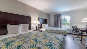 A hotel room with two beds, a desk, a chair, and a window with curtains. - Motel6 Dallas, TX - Downtown (Dallas)