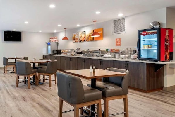A modern hotel room with a dining area, a kitchen counter, and a refrigerator. - Tryp by Wyndham Tallahassee North I-10 Capital Cir (Tallahassee)