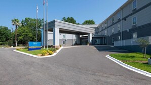 A building with a covered entrance, a sign reading 'TRYP,' and a parking lot. - Tryp by Wyndham Tallahassee North I-10 Capital Cir (Tallahassee)