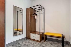A room with a wardrobe, a bench, and a mirror. - Tryp by Wyndham Tallahassee North I-10 Capital Cir (Tallahassee)