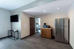 A compact kitchen with a refrigerator, microwave, and a small table. - Tryp by Wyndham Tallahassee North I-10 Capital Cir (Tallahassee)